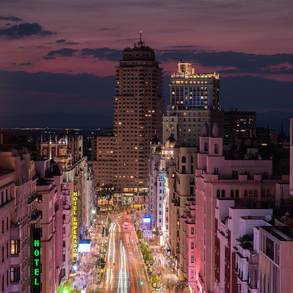 Illuminated buildings along Gran Vía showing Madrid's lively evening atmosphere.