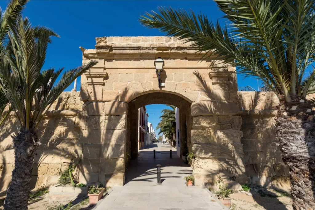 Historic walled village of Tabarca Island, with traditional stone gateways and Mediterranean architecture.